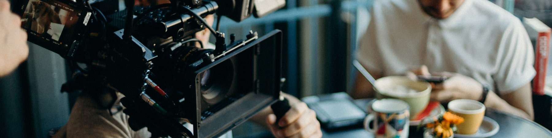 Person filming in a cafe